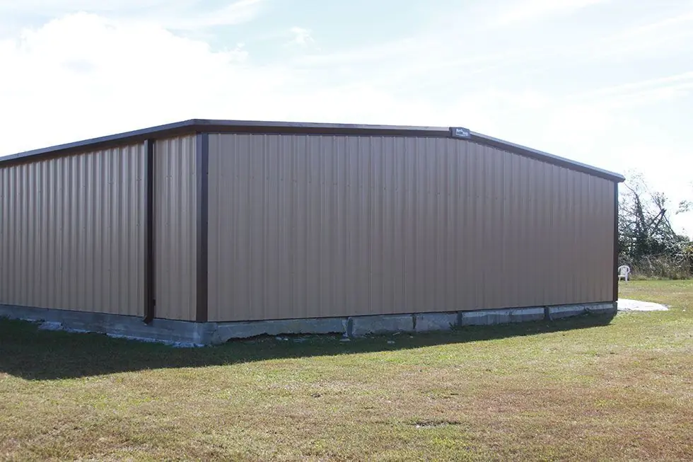 Finished tan and brown metal building photographed on a clear day after completion