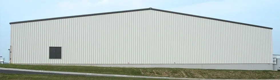 Wide side elevation of a large white metal commercial building erected by Hall Construction